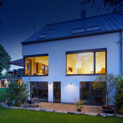 solar LED wall lights installed on the walls of the exterior os a home lighting a small patio area